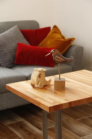 Una mesa de madera con una escultura de pájaro de madera y una escultura de caballo de madera.