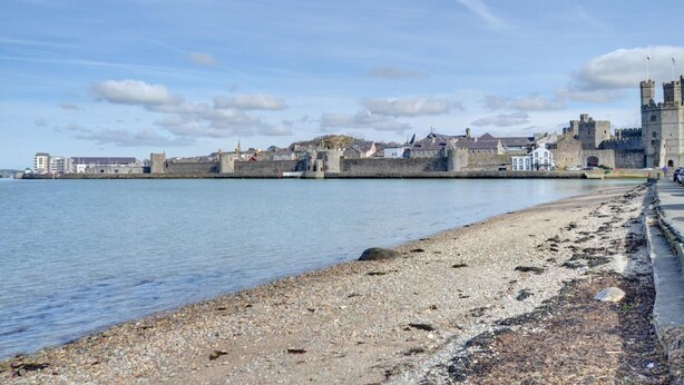 Une ville côtière dotée d’un château historique, d’une plage de galets et d’une mer calme.