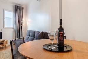 A round wooden table with a bottle of wine and two glasses on a tray. - Panorama View Apartment in Beautiful Viewpoint (Lisbon)