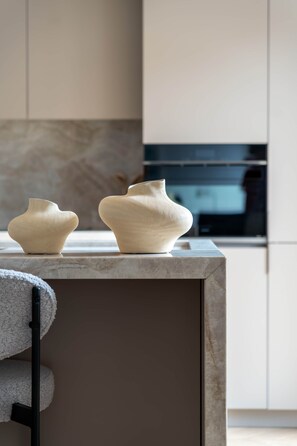 A kitchen with two white ceramic vases on a marble countertop. - Príncipe Signature Residence (Madrid)