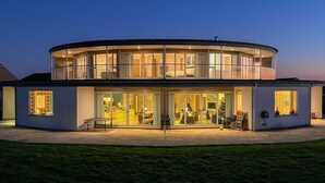 Ein modernes, zweistöckiges Gebäude mit großen Glasfenstern und einer flachen Dachfläche.