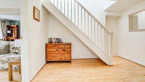 A room with a wooden floor, a staircase, a wooden dresser, and a framed picture on the wall. - 2 Bed in Salhouse (oc-1250) (Salhouse)
