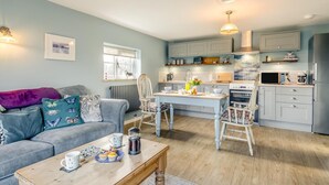Un salon confortable avec un canapé, une table basse et un coin repas comprenant une table et des chaises.