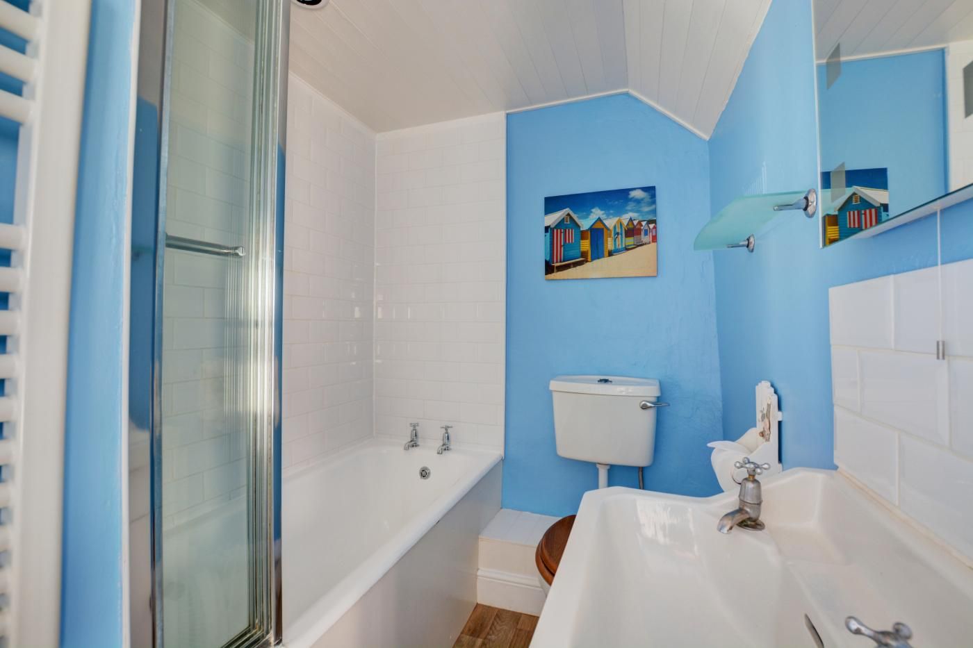 Een badkamer met een douche, bad, toilet en wastafel.