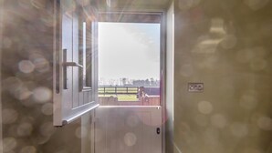 Une porte ouverte donnant sur une cour extérieure clôturée.