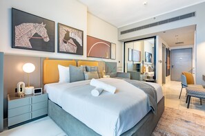 A modern hotel room with a large bed, bedside tables, a desk, and a mirror. - Sky-High Studio with Stunning City Views, Just a Stone’s Throw from Dubai Mall (Dubai)