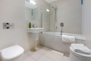 Ein modernes Badezimmer mit Toilette, Waschbecken, Dusche und Badewanne.