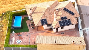 A residential property with a swimming pool, solar panels, and a star-shaped design on the patio.