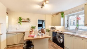 Een moderne keuken met een centraal eiland, ingebouwde apparatuur en uitzicht op de stad.
