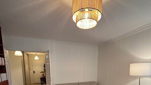 Een moderne woonkamer met een bank, voetenbankje, salontafel en een lamp.