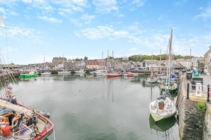 A harbor with various boats docked, a clear sky, and buildings in the background. - 2 Bed in Padstow (oc-p00557) (Padstow)