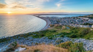 Une ville côtière avec une plage, des maisons et un ciel dégagé.