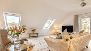 A spacious living room with a sofa, a glass coffee table, a TV, and a ceiling fan. - 2 Bed in Duddlestone (oc-q34588) (Duddlestone)