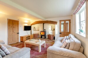 A cozy living room with a fireplace, a television, and comfortable seating. - 3 Bed in Cundall (oc-l34088) (Cundall)