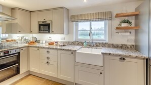 A modern kitchen with a built-in oven, microwave, and stainless steel sink. - 3 Bed in Cundall (oc-l34088) (Cundall)