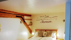 Quarto com cama de madeira, luz na parede e radiador.