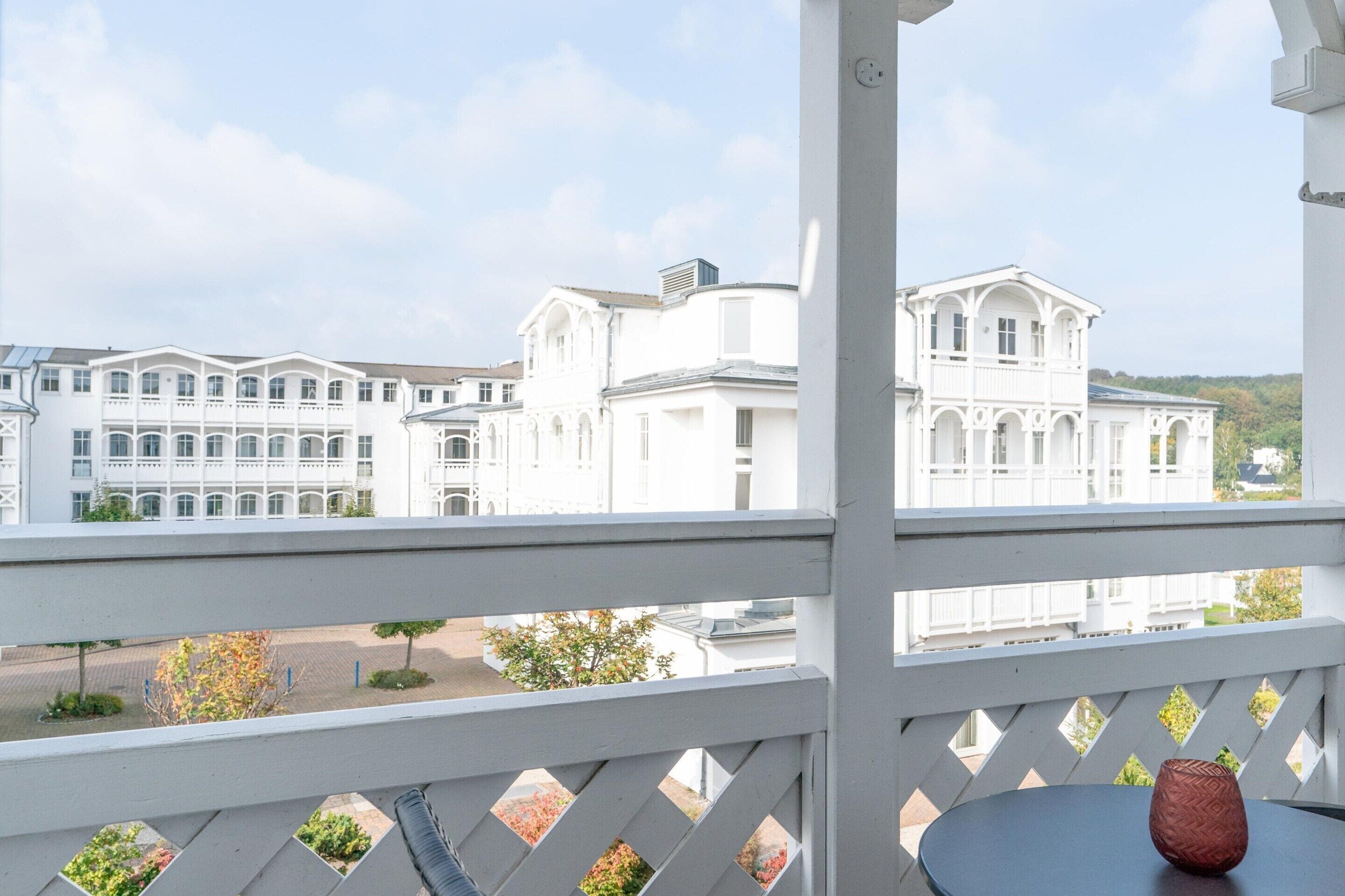A balcony with a view of white buildings and a clear sky.