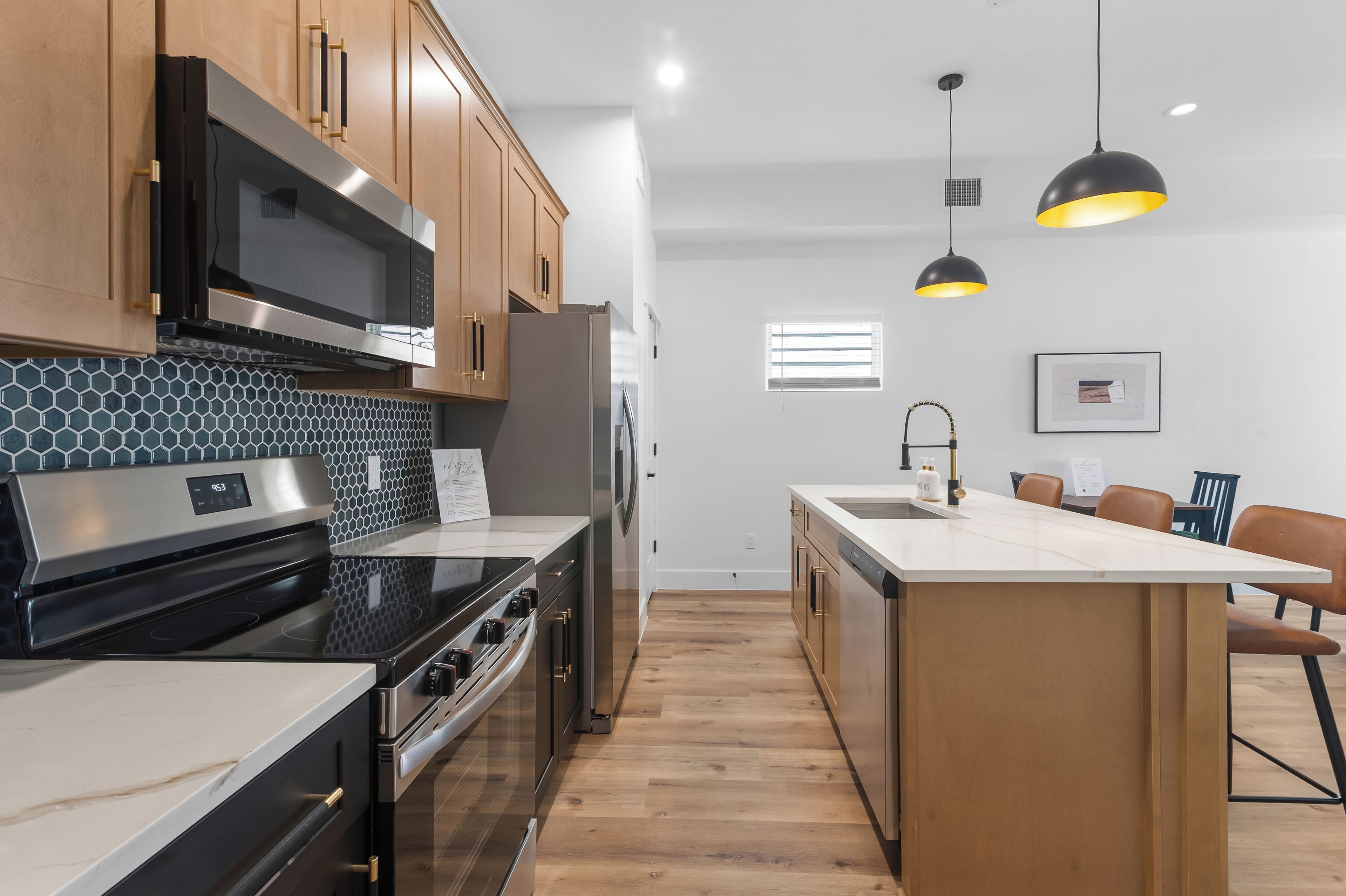 A modern kitchen with stainless steel appliances, wooden cabinets, and a central island.