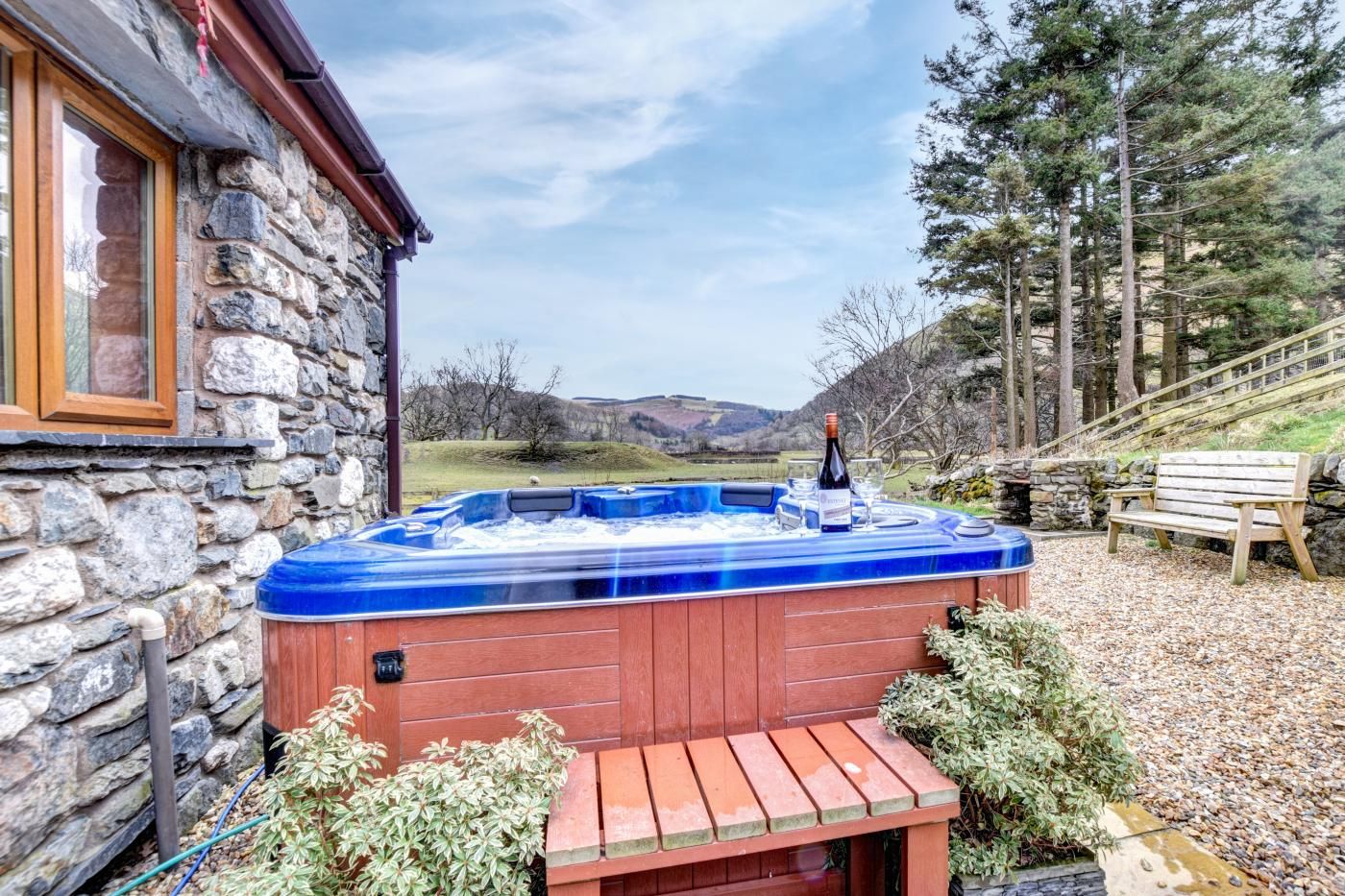 Ein Steinhäuschen mit Whirlpool im Garten.