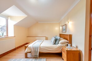 A bedroom with a skylight, a bed with pillows, a bedside table, and a radiator. - 3 Bed in Lampeter (oc-49161) (Silian)