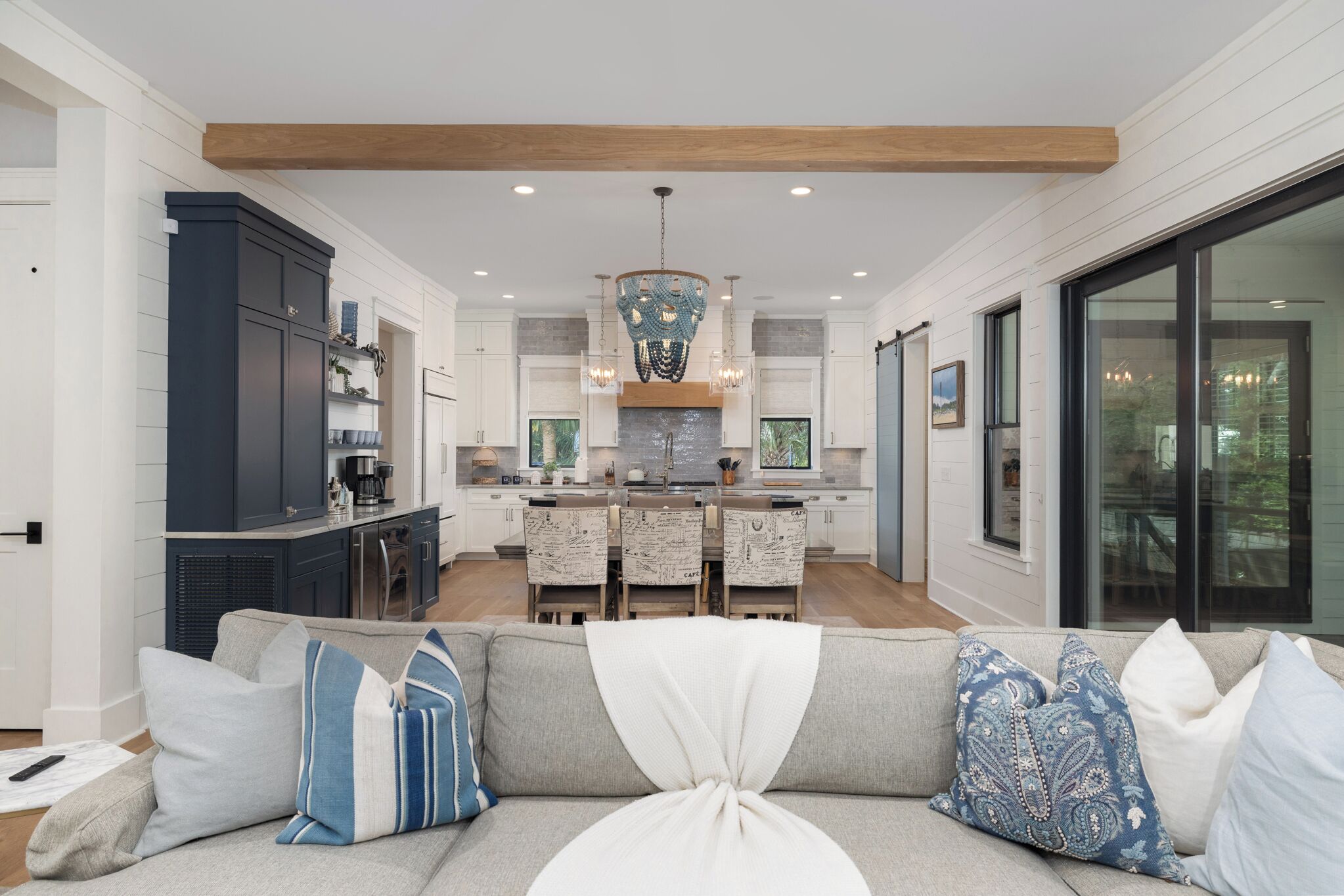 A modern living room with a sofa, a dining area, and a kitchen.