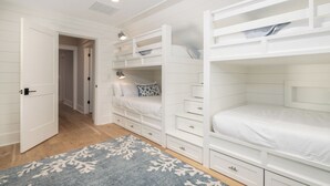 A bedroom with bunk beds, a walk-in closet, and a patterned rug. - Stay @ Isle of Coladas (Isle of Palms)