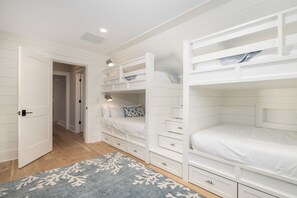 A bedroom with bunk beds, a walk-in closet, and a patterned rug. - Stay @ Isle of Coladas (Isle of Palms)