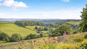 A rural landscape with rolling hills, a wooden fence, and a small building. - 1 Bed in Welshpool (oc-381818) (Welshpool)