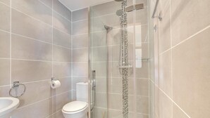 Ein modernes Badezimmer mit einer Duschkabine, einer Toilette und einem Waschbecken.