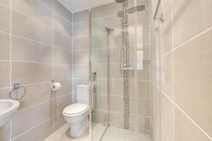 Ein modernes Badezimmer mit einer Duschkabine, einer Toilette und einem Waschbecken.