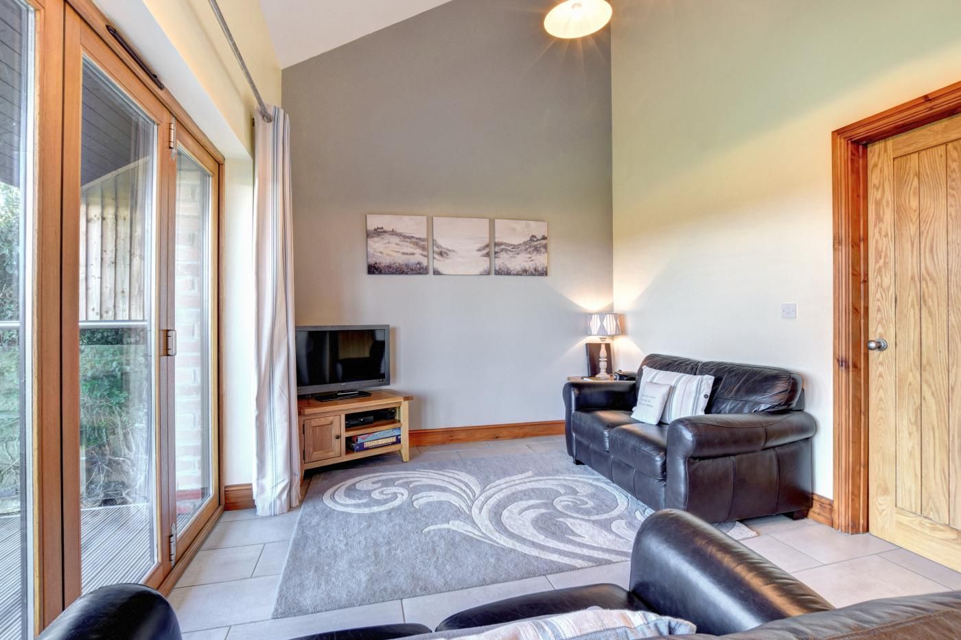 A living room with a sofa, TV, and artwork on the wall.