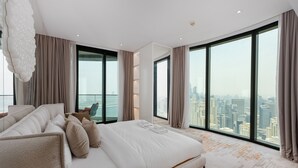 A modern bedroom with a large bed, city view, and a high-rise building in the background. - Address JBR 3BR Direct Beach Ain Dubai View (Dubai)