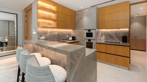 A modern kitchen with a marble island, wooden cabinets, and built-in appliances. - Address JBR 3BR Direct Beach Ain Dubai View (Dubai)