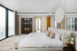 Ein modernes Hotelzimmer mit einem großen Bett, Blick auf die Stadt und einem großen Fenster.