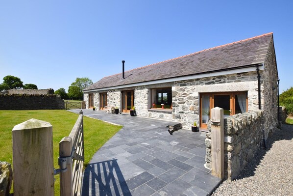 A stone building with a tiled entrance and a wooden fence. - 4 Bed in Menai Bridge (oc-bow16) (Menai Bridge)