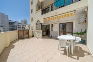 A rooftop terrace with a table and chairs, a potted plant, and a view of the cityscape. - Casa Cruzeiro Praia da Rocha (Portimão)