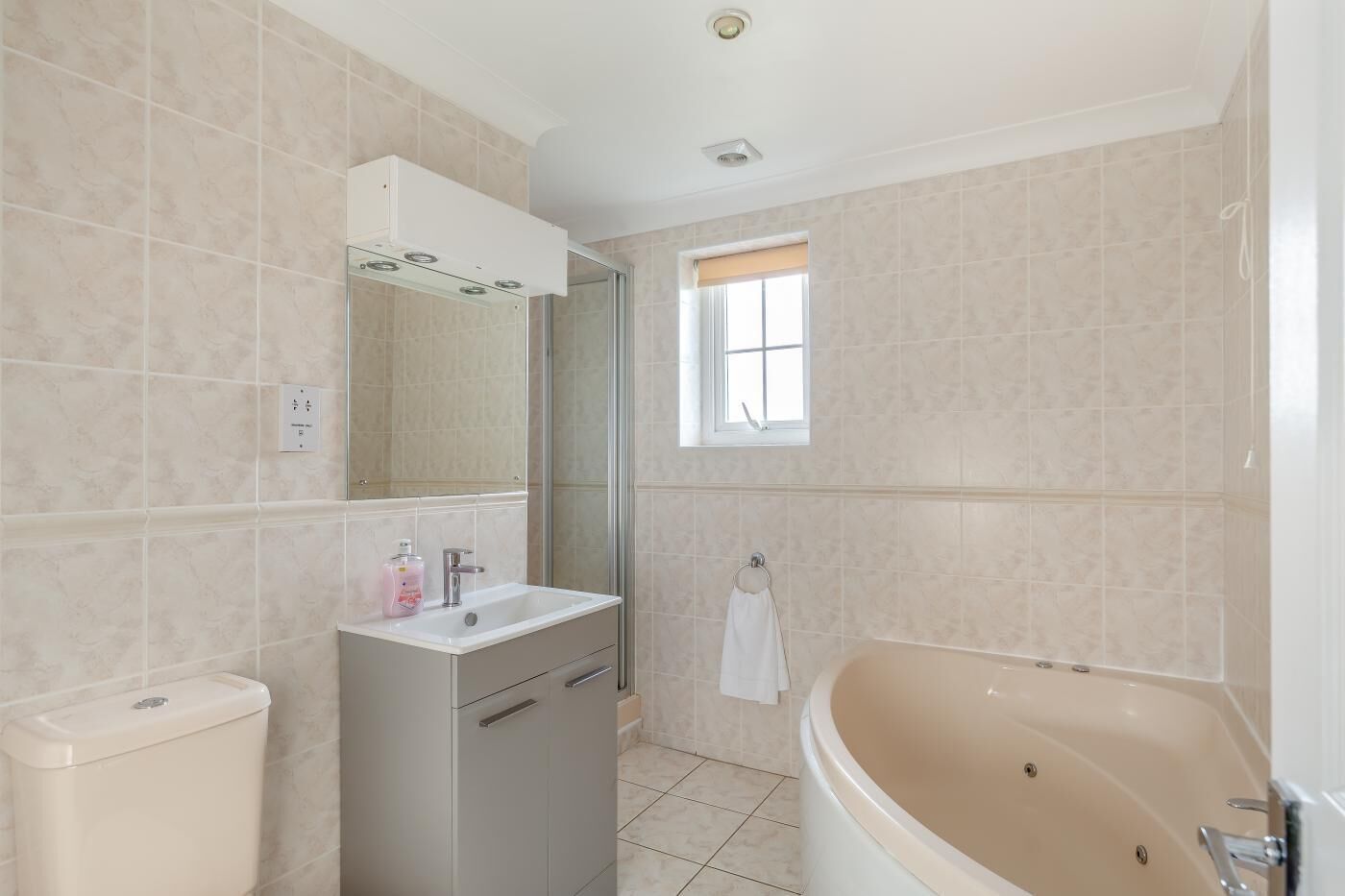 Une salle de bain comprenant des toilettes, un lavabo, un miroir et une baignoire.