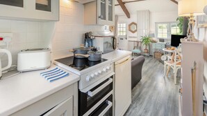 A compact kitchen with a gas stove, a toaster, and a sink. - 1 Bed in St. Gennys (oc-r34472) (Rosecare)