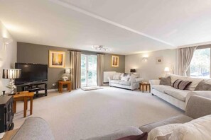 A modern living room with a flat-screen TV, two sofas, a coffee table, and a fireplace. - 4 Bed in Stoney Middleton (oc-c34609) (Stoney Middleton)