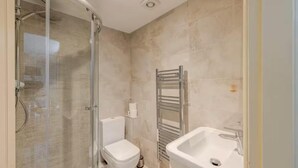 A bathroom with a glass shower enclosure, a white toilet, a towel rack, and a sink. - 3 Bed in Stoney Middleton (oc-c34611) (Stoney Middleton)
