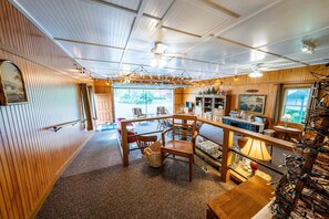 A cozy interior with a wooden bar area, seating, and a view through large windows. - Superb 2-bedroom house in Cannon Falls perfect for relaxing getaway (Cannon Falls)