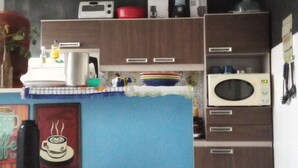 A kitchen with a microwave, stove, and various kitchen items on the counter.