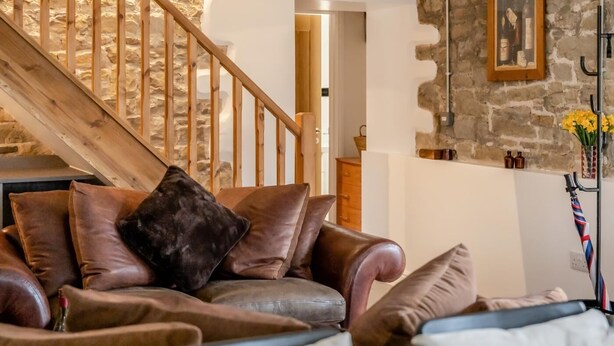 A room with a wooden staircase, a stone wall, a framed picture, and a coat rack with an umbrella. - 3 Bed in Gilsland (oc-f34699) (Waterhead)