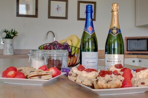 A table with pastries, strawberries, and two bottles of champagne. - 3 Bed in Welshpool (oc-bow122) (Welshpool)