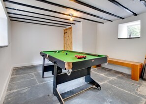 A pool table with balls, a wooden bench, and a window with a view. - 4 Bed in Ruthin (oc-bow136) (Gwyddelwern)