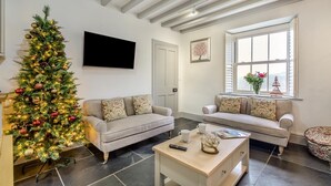Ein Wohnzimmer mit Weihnachtsbaum, zwei Sofas, einem Couchtisch, einem Flachbildfernseher und einem Fenster mit Blick.