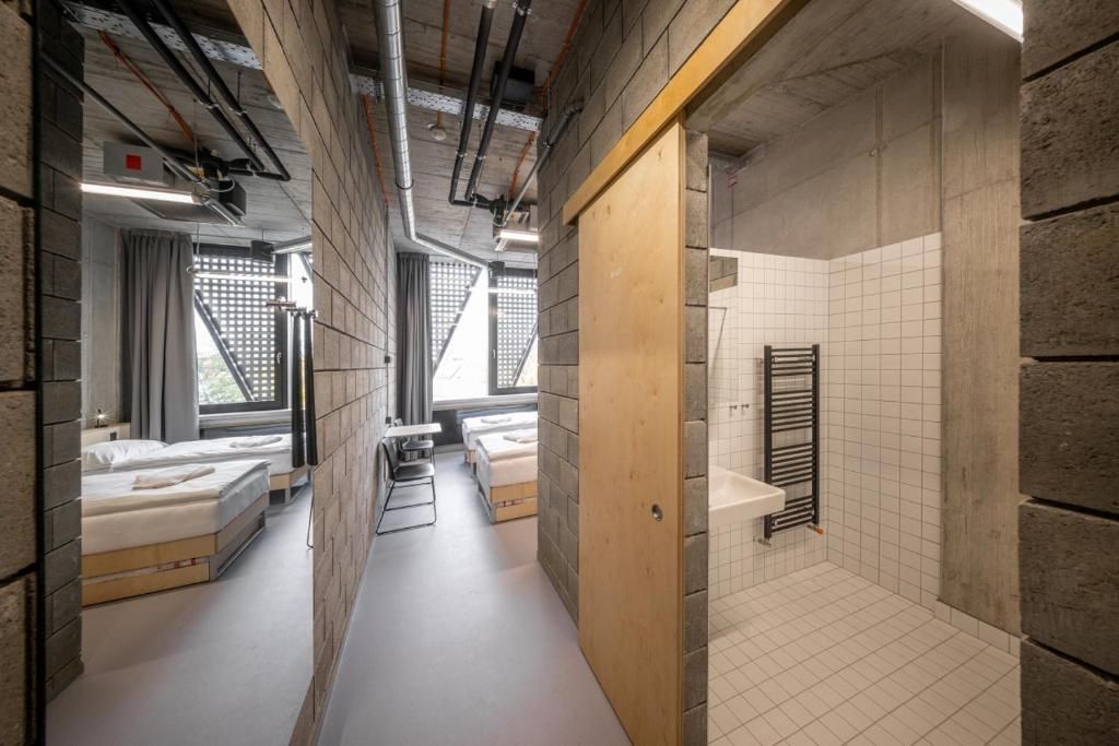 Un couloir étroit, avec une douche sur le côté droit, un lit sur le côté gauche et une fenêtre donnant sur un beau paysage.