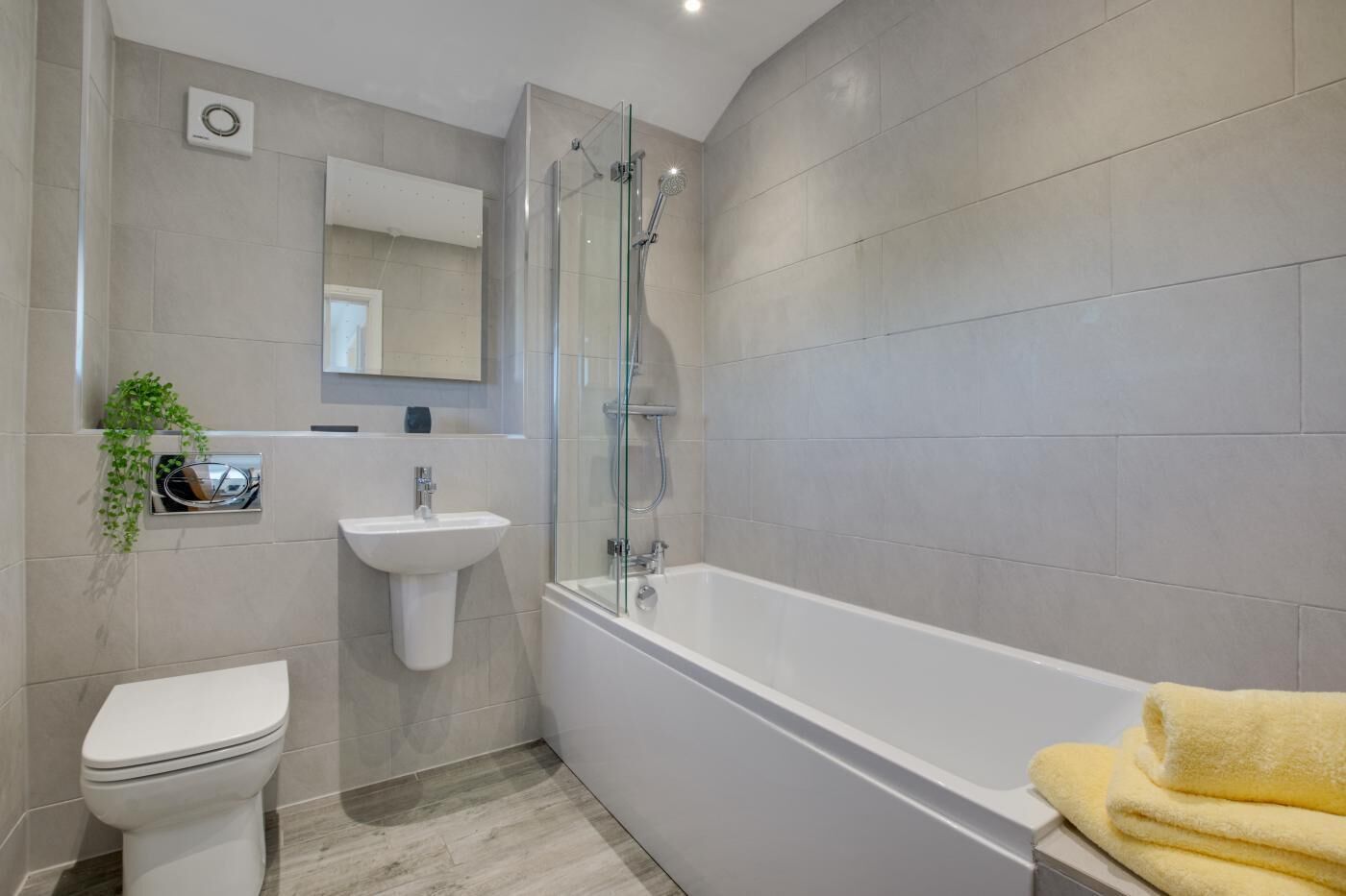 A modern bathroom with a toilet, sink, and bathtub.