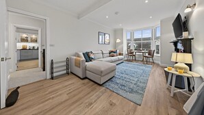 Uma sala moderna com sofá, mesa de centro e área de jantar com cadeiras.