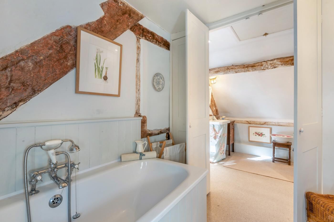 A bathroom with a bathtub, a shower, and a rustic wooden beam.